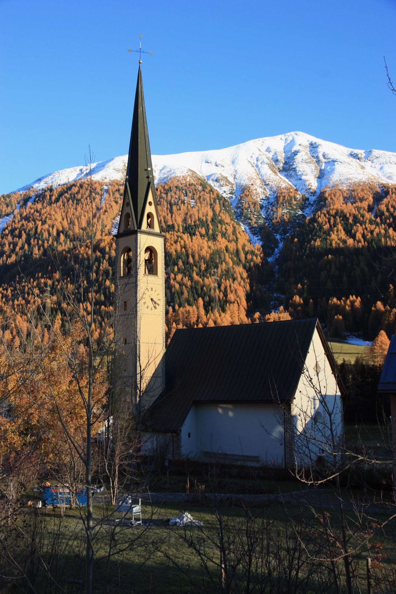 The reformist church in S-chanf in the afternoon sun of autumn.